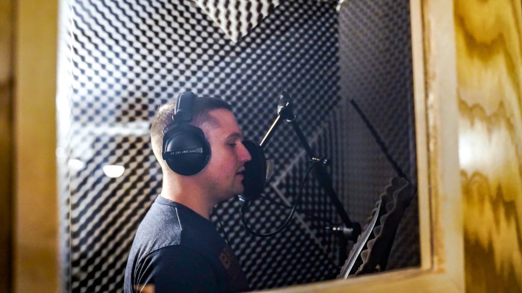 Podcast Host Reading a Script in a Sound-Treated Room