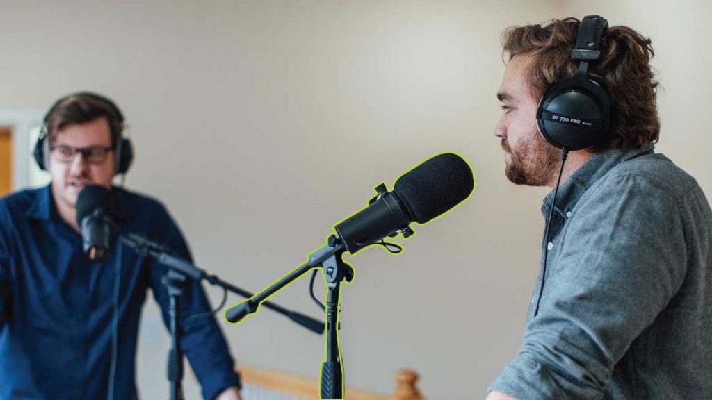 Two men recording a podcast with a mic stand highlighted in green