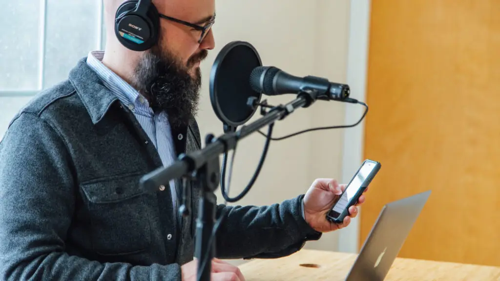 What is a podcast? A plain explainer from a production team 2 Man listening to a podcast on a smartphone